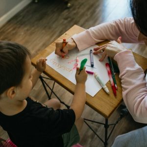 Persona adulta y menor realizando una actividad educativa juntos