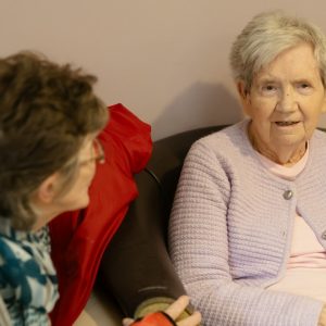 Dos personas mayores conversando en un entorno de acompañamiento